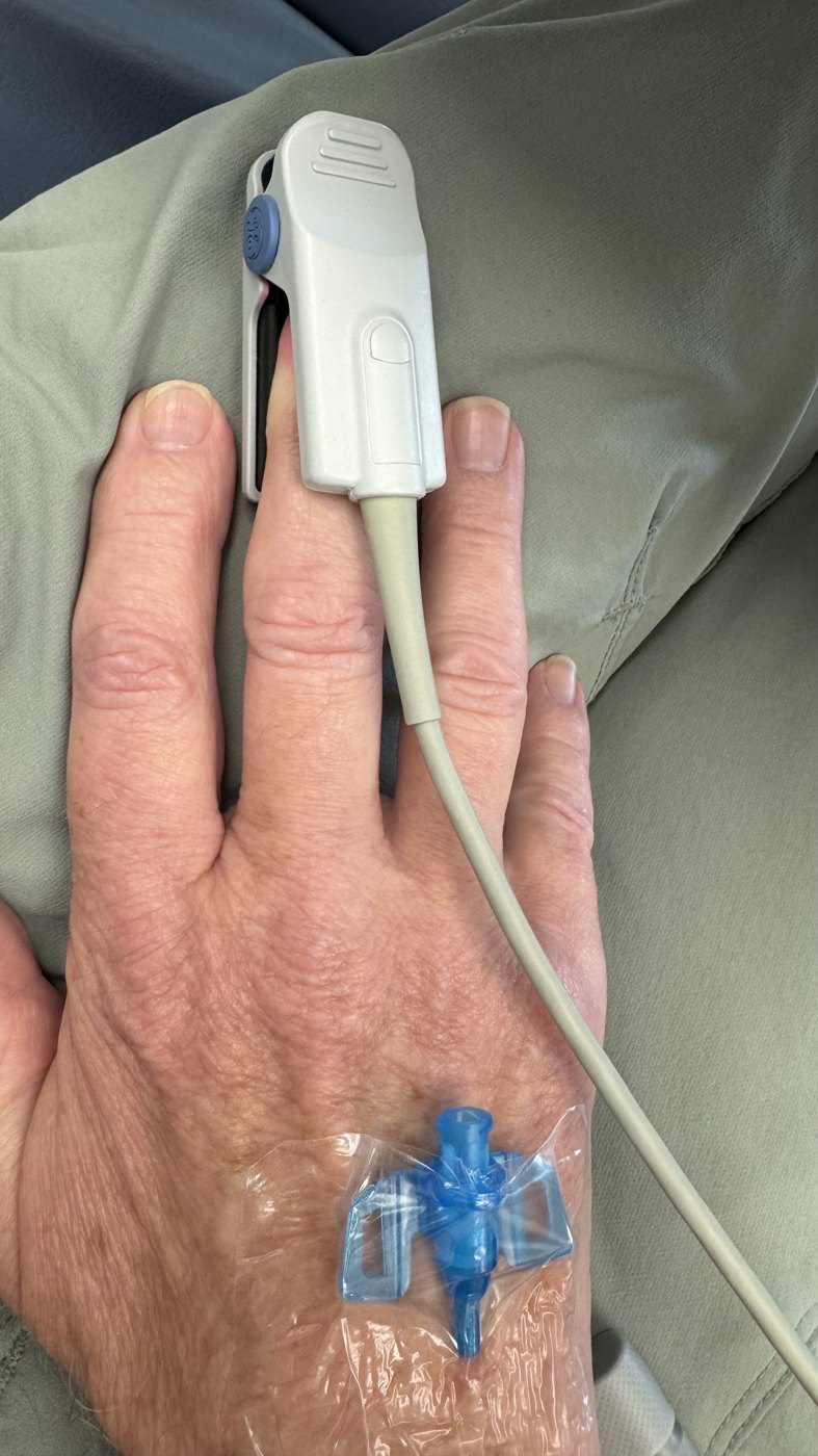 Reusable finger pulse oximeter probe clipped to a patient finger.